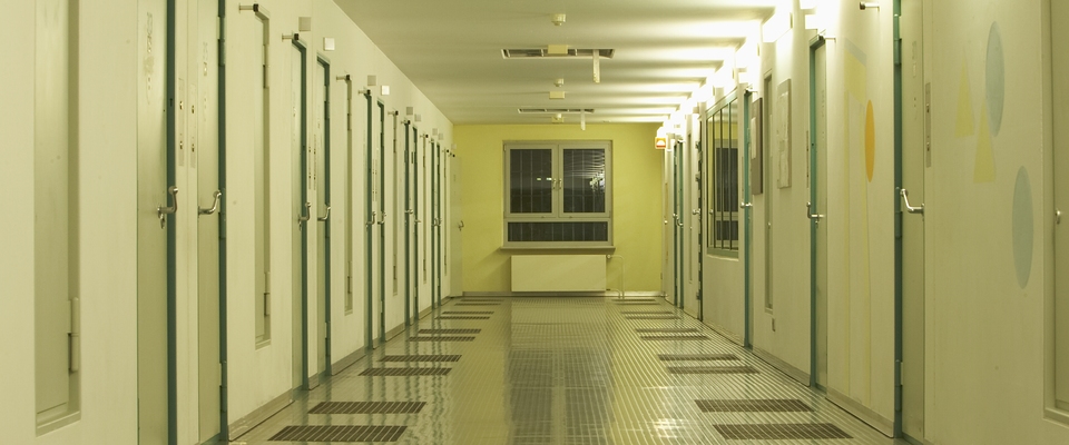 Flur einer Haftabteilung mit Haftraumtüren auf jeder Seite